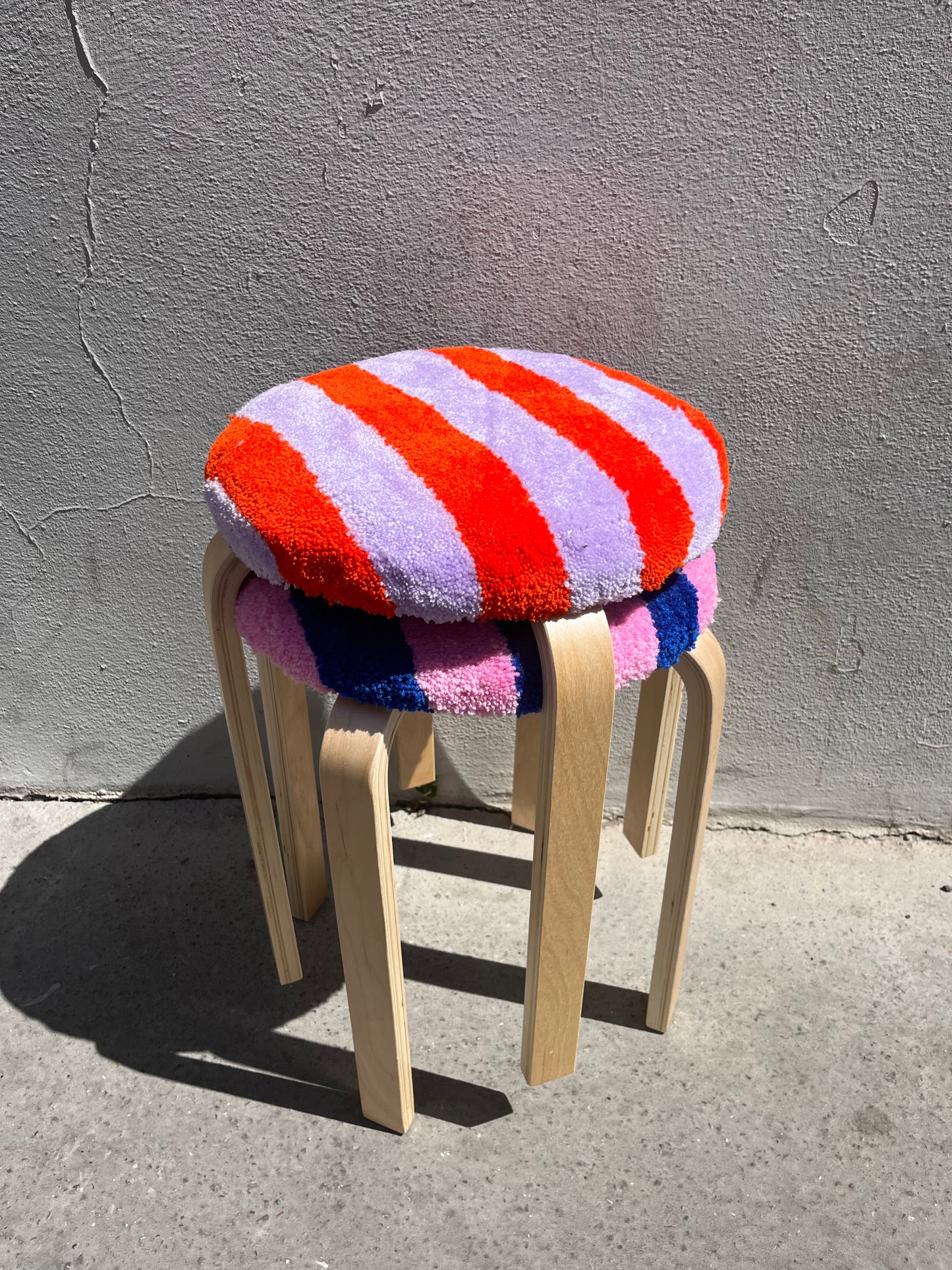 Tabouret tufté rayé orange et lila